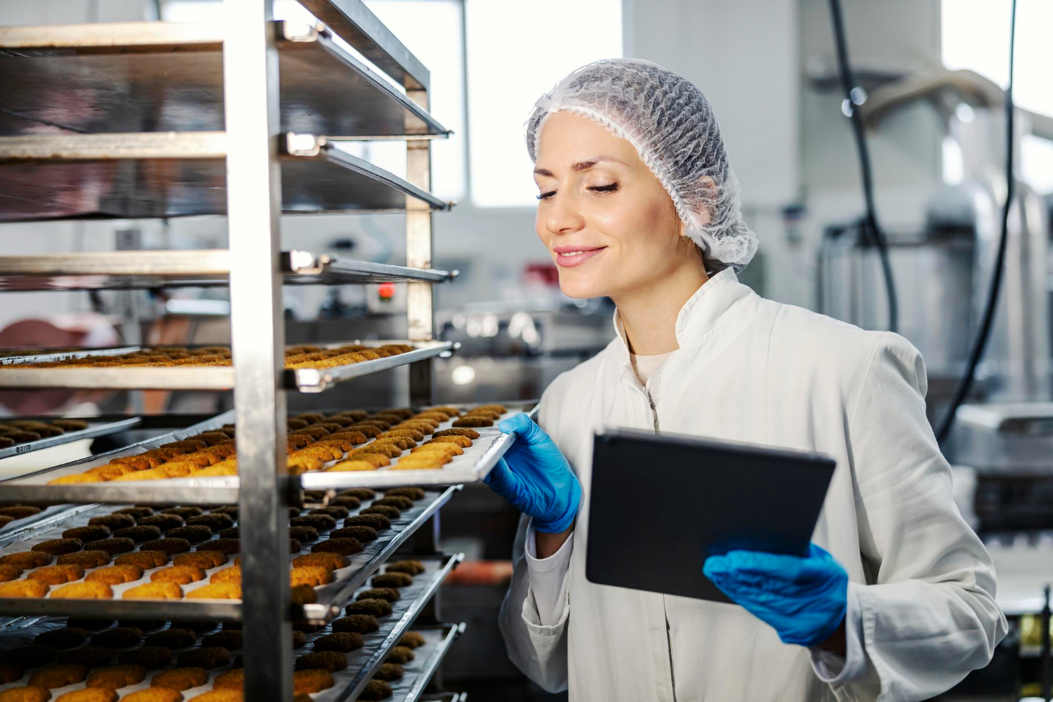 Bakery worker using a tablet to perform a quality inspection on the production floor